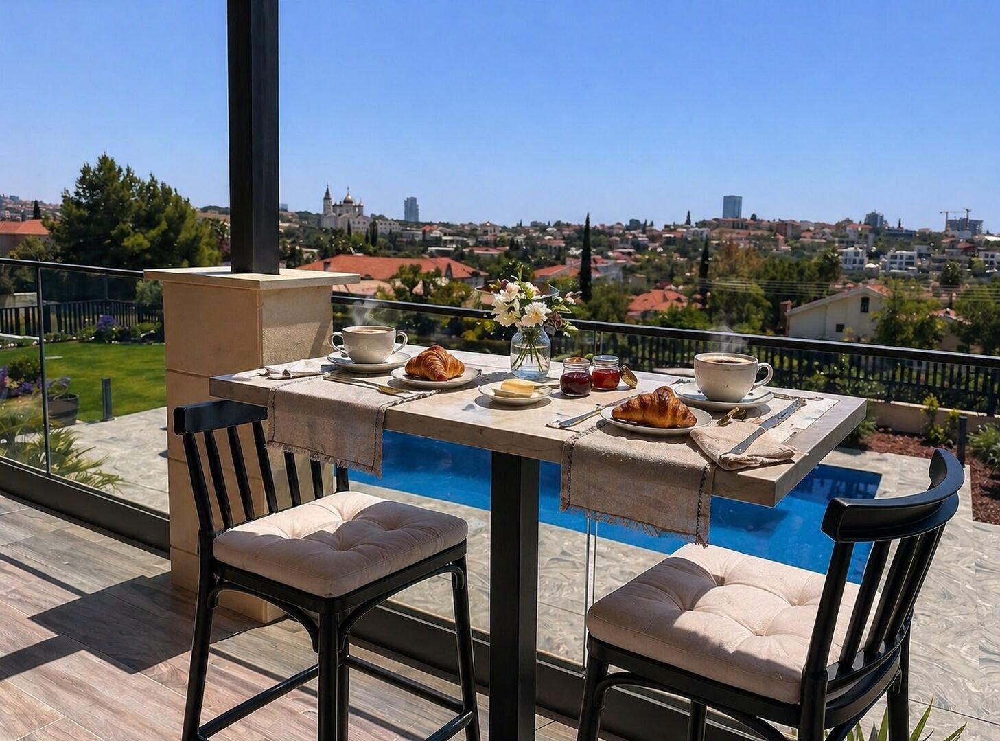 Breakfast with croissants and coffee on the terrace overlooking the pool and Limassol skyline